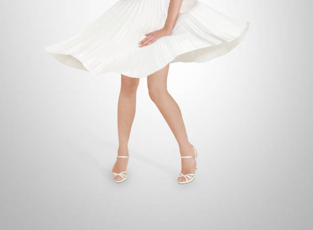 Woman in white dress with flying skirts. studio shoot